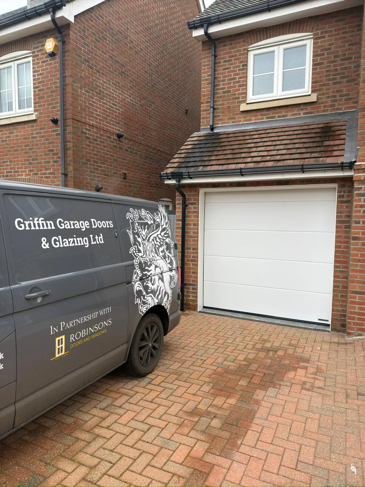 white garage door and branded grey van